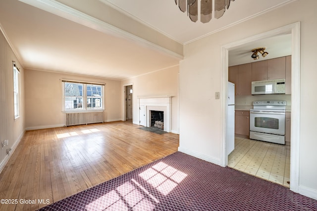 unfurnished living room with a fireplace with flush hearth, light wood-style flooring, ornamental molding, radiator, and baseboards