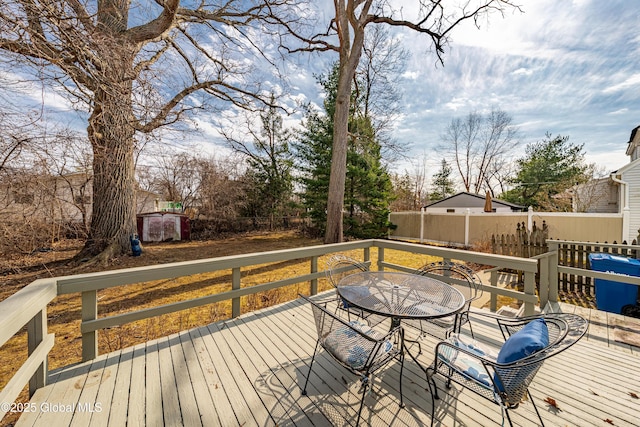 wooden terrace with outdoor dining space and fence