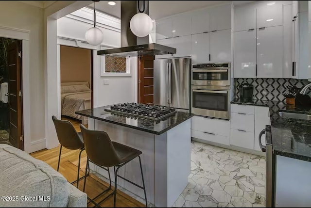 kitchen featuring range hood, appliances with stainless steel finishes, modern cabinets, and a sink