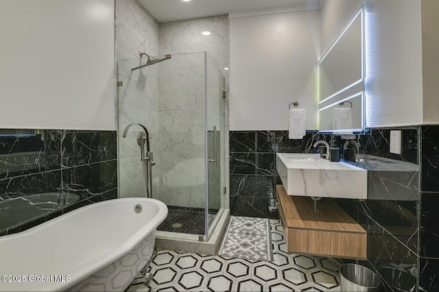 bathroom featuring double vanity, a freestanding tub, tile walls, and a stall shower