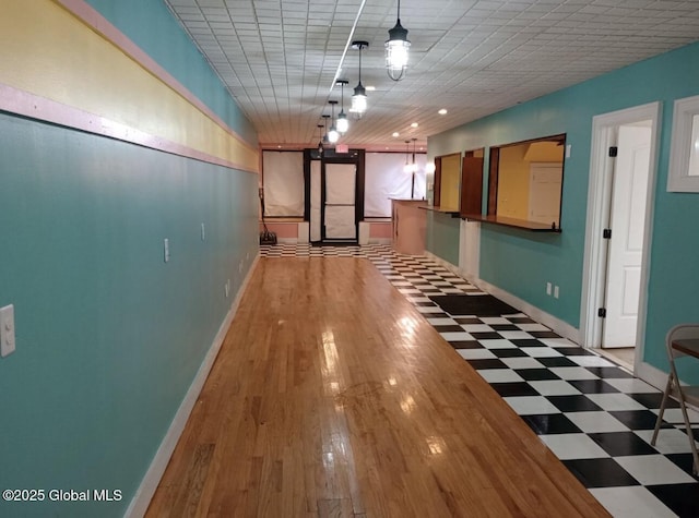 hallway with tile patterned floors and baseboards