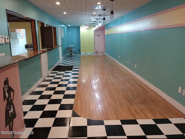 interior space with tile patterned floors, a paneled ceiling, baseboards, and recessed lighting