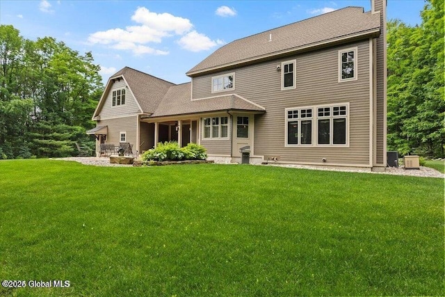 back of house with cooling unit, a lawn, and a chimney