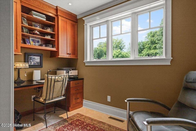 office featuring visible vents, built in desk, crown molding, light tile patterned floors, and baseboards