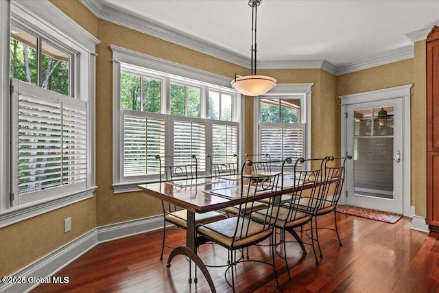 dining room featuring dark wood-type flooring, baseboards, and ornamental molding