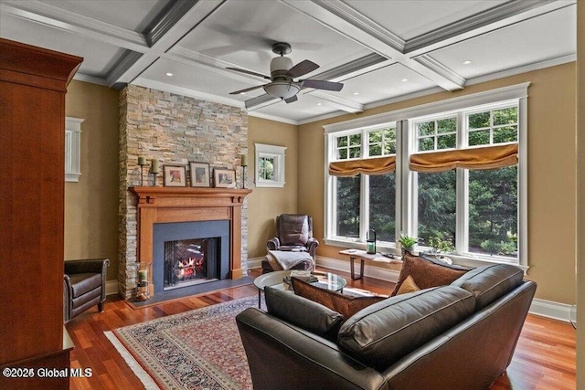 living area featuring crown molding, wood finished floors, coffered ceiling, and a large fireplace