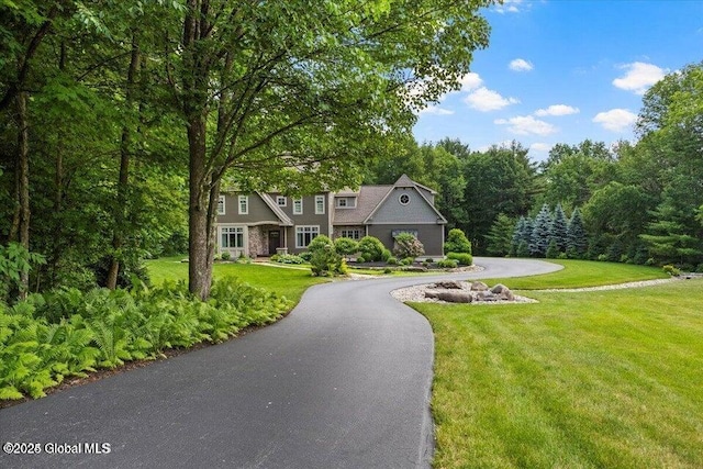 shingle-style home with a front yard and aphalt driveway