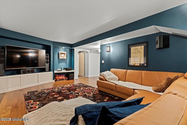 living area featuring arched walkways and wood finished floors