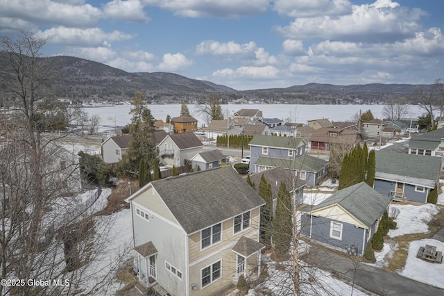 snowy aerial view featuring a mountain view and a residential view