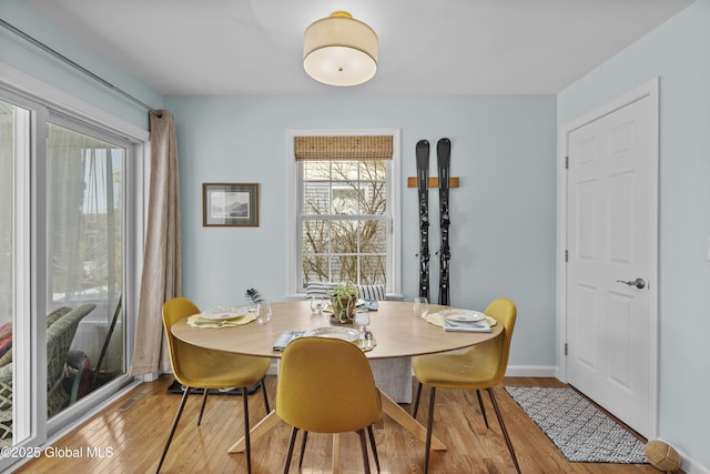 dining space with baseboards and wood finished floors