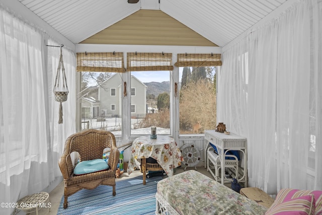 sunroom / solarium featuring a mountain view and vaulted ceiling