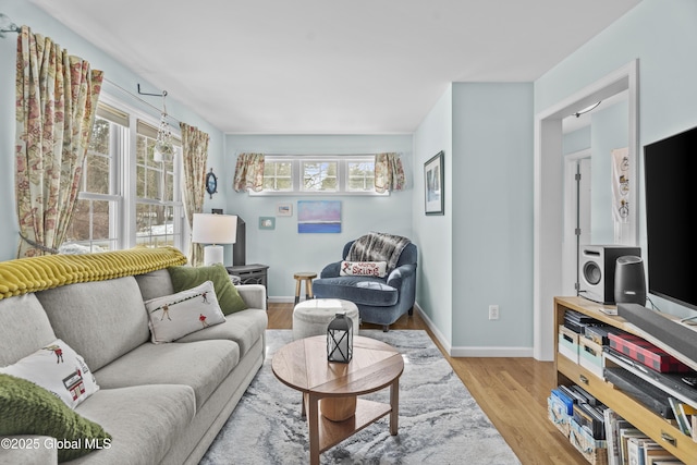 living area featuring baseboards and light wood finished floors