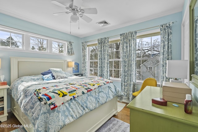 bedroom featuring visible vents, a ceiling fan, and wood finished floors