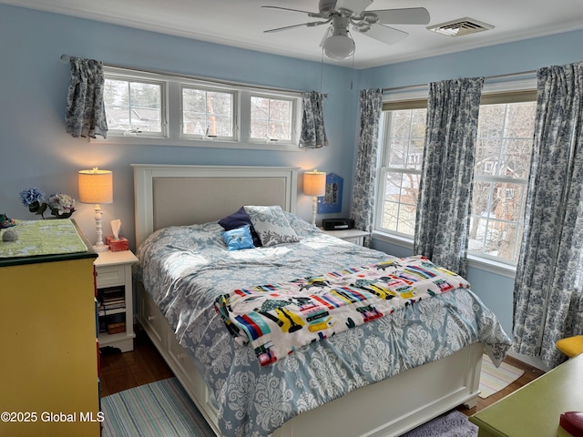 bedroom featuring a ceiling fan, wood finished floors, and visible vents