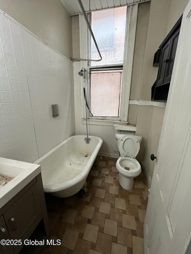 bathroom with vanity, tile walls, and toilet