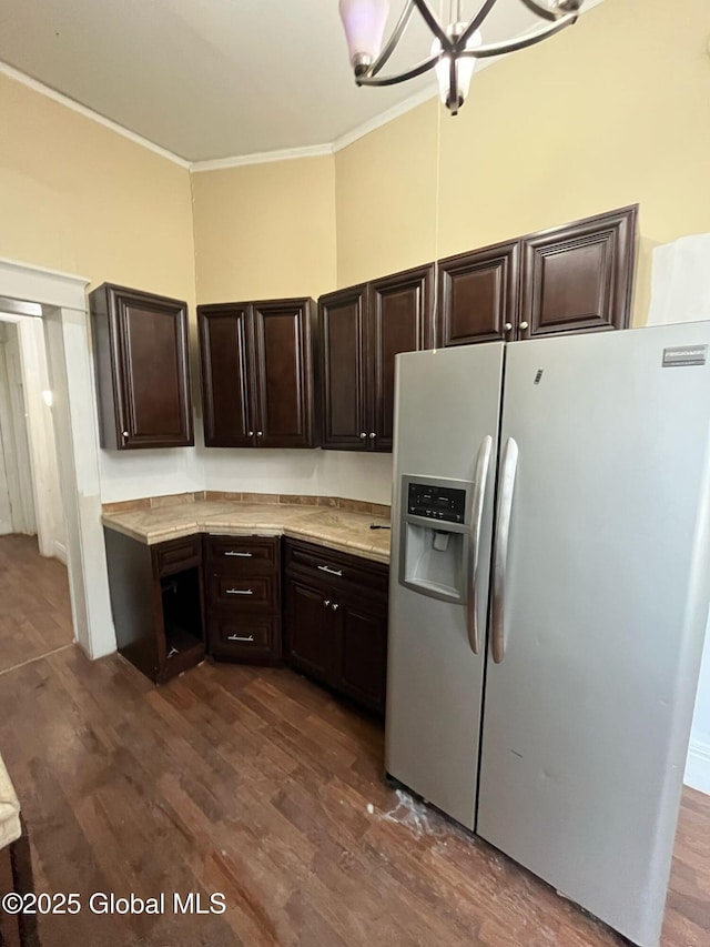 kitchen with dark brown cabinets, light countertops, crown molding, and white fridge with ice dispenser