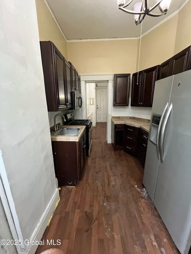 kitchen with a sink, dark wood-style floors, dark brown cabinetry, appliances with stainless steel finishes, and crown molding