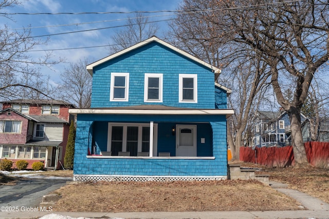 view of front of home with a porch and fence