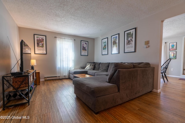 living room featuring baseboards, wood-type flooring, and a textured ceiling