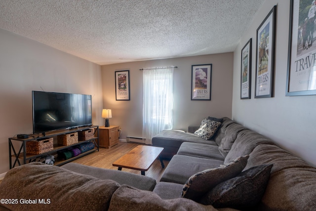 living room featuring a baseboard heating unit, a textured ceiling, and light wood finished floors