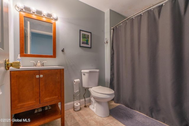 bathroom featuring baseboards, toilet, a shower with shower curtain, tile patterned floors, and vanity