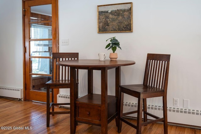 dining room featuring a baseboard heating unit, wood finished floors, and radiator heating unit