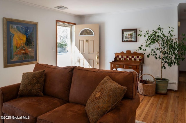 living area featuring visible vents, crown molding, and wood finished floors