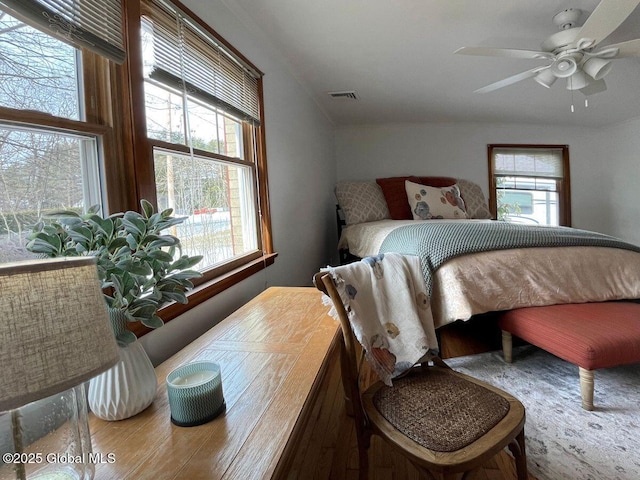 bedroom featuring multiple windows, visible vents, and ceiling fan