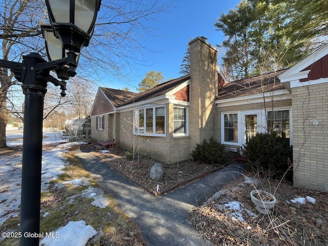 view of home's exterior featuring brick siding and a chimney