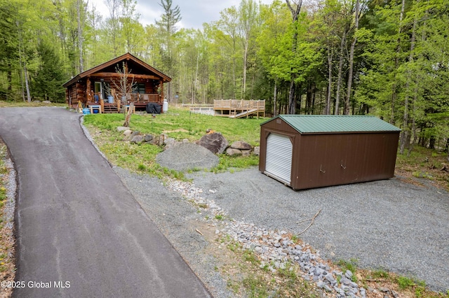 465 Barlow Rd, Bleecker, NY 12078 - view of front of house featuring covered porch, a view of trees, an outbuilding, and a garage