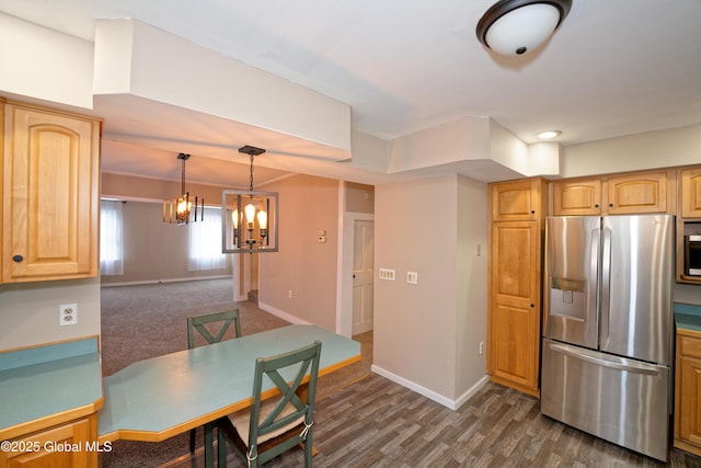 kitchen featuring a notable chandelier, baseboards, light brown cabinetry, and stainless steel appliances