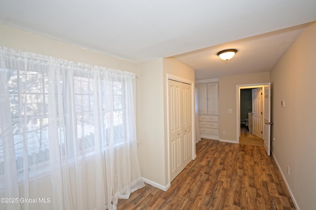 hall with baseboards and wood finished floors