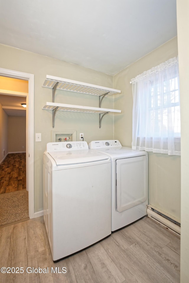 washroom featuring washer and clothes dryer, light wood-style flooring, laundry area, and a baseboard radiator