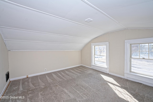 additional living space featuring lofted ceiling, carpet flooring, baseboards, and visible vents