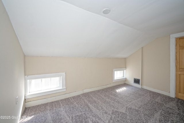 bonus room featuring vaulted ceiling, carpet, and visible vents