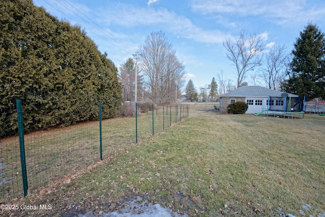 view of yard with a trampoline and fence