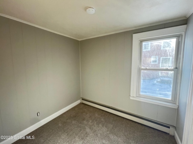 empty room with a baseboard heating unit, baseboards, ornamental molding, and dark carpet