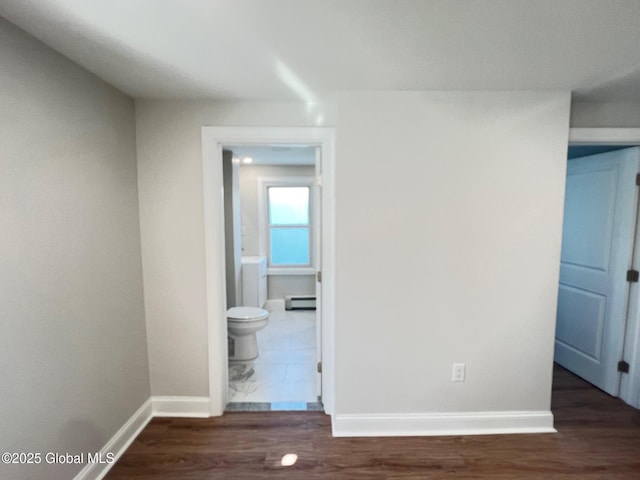 corridor featuring dark wood-style floors, baseboards, and baseboard heating