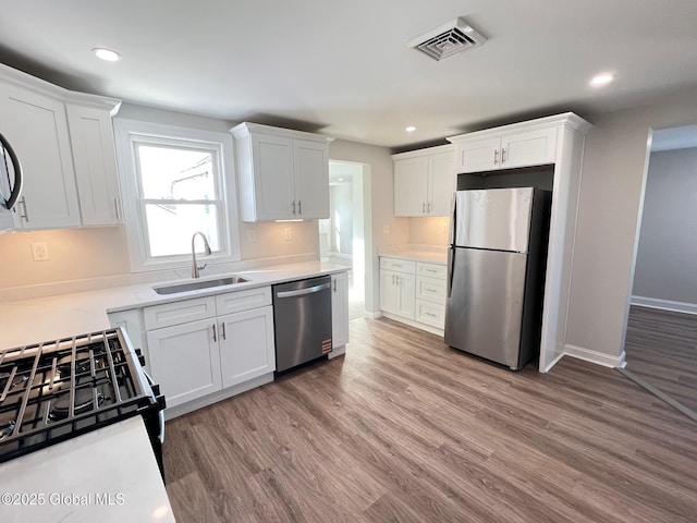 kitchen with white cabinetry, visible vents, appliances with stainless steel finishes, and a sink