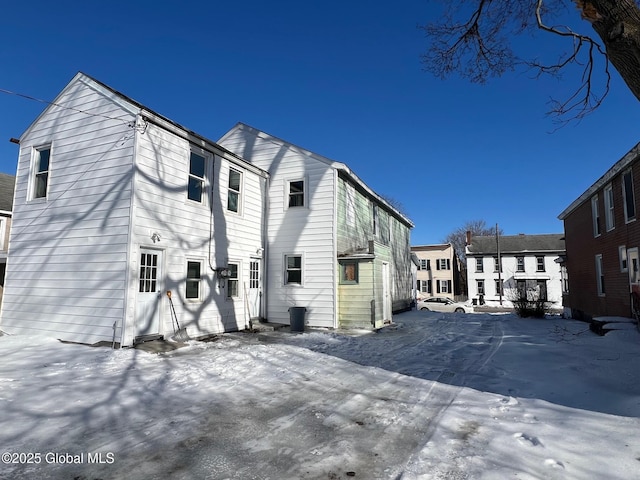 view of snow covered rear of property