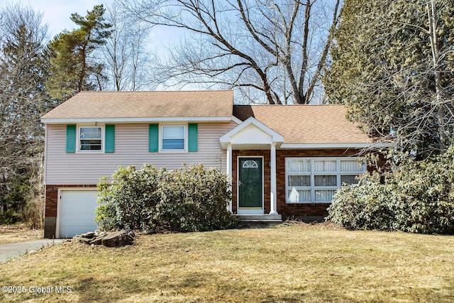 split level home with driveway, a front yard, a garage, and roof with shingles