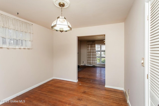 unfurnished dining area with baseboards and wood finished floors