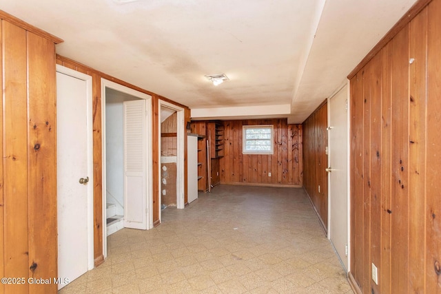 hallway featuring wooden walls and light floors