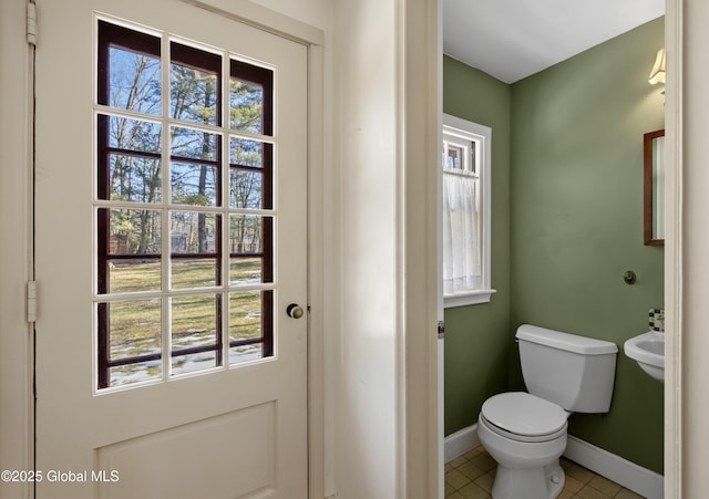 bathroom featuring tile patterned floors, toilet, and baseboards