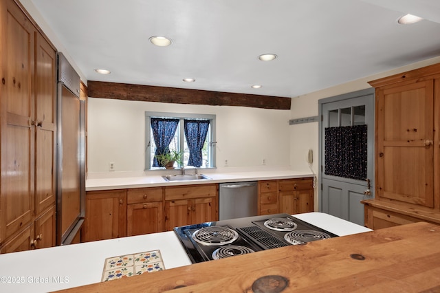 kitchen featuring brown cabinetry, a sink, light countertops, built in refrigerator, and dishwasher