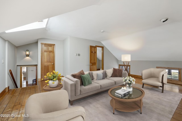 living room with lofted ceiling with skylight and light wood-type flooring