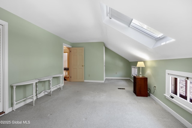 bonus room featuring lofted ceiling with skylight, baseboards, and carpet