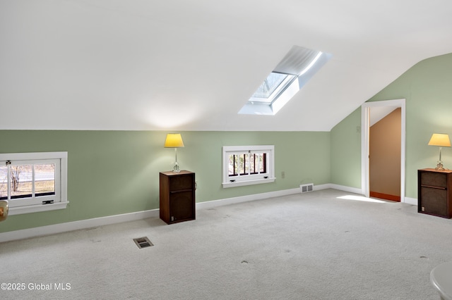 bonus room with lofted ceiling with skylight, carpet flooring, baseboards, and visible vents