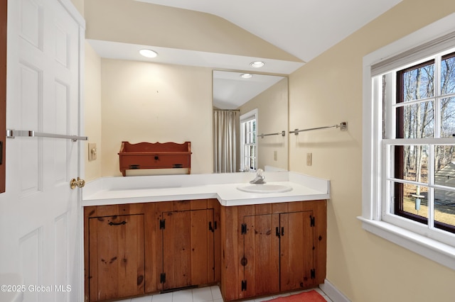 bathroom featuring recessed lighting, vanity, and lofted ceiling