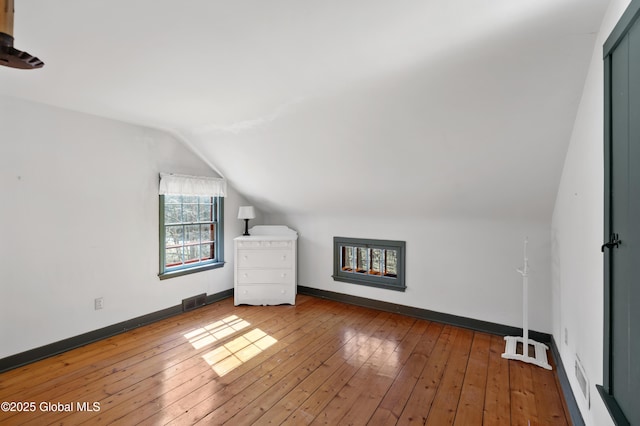 bonus room with vaulted ceiling, baseboards, visible vents, and wood-type flooring